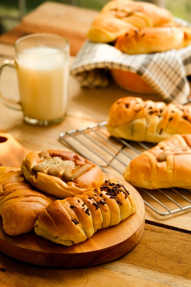 Bread rolls and a glass of milk on a wooden table